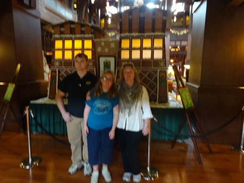 family in front of gingerbread house