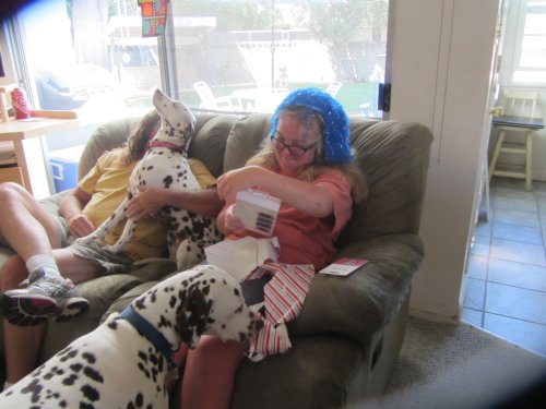 Missy openeing presents with assistance from Lucky
