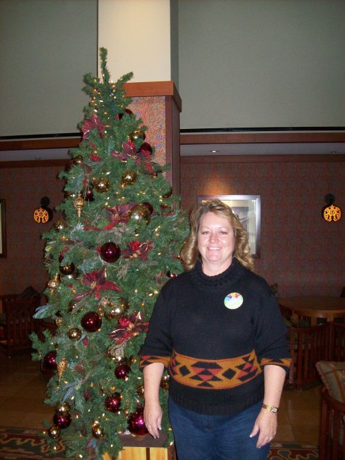 Lori in front of Christmas tree in concierge lounge 