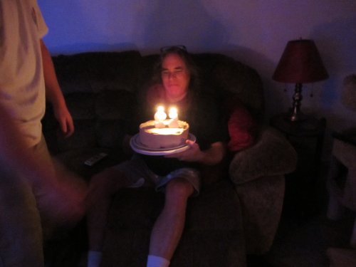Dad blowing out candles on cake 
